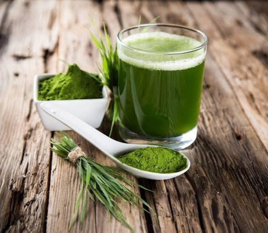Smoothie ingredients with spirulina and hemp seeds beside a glass blender cup